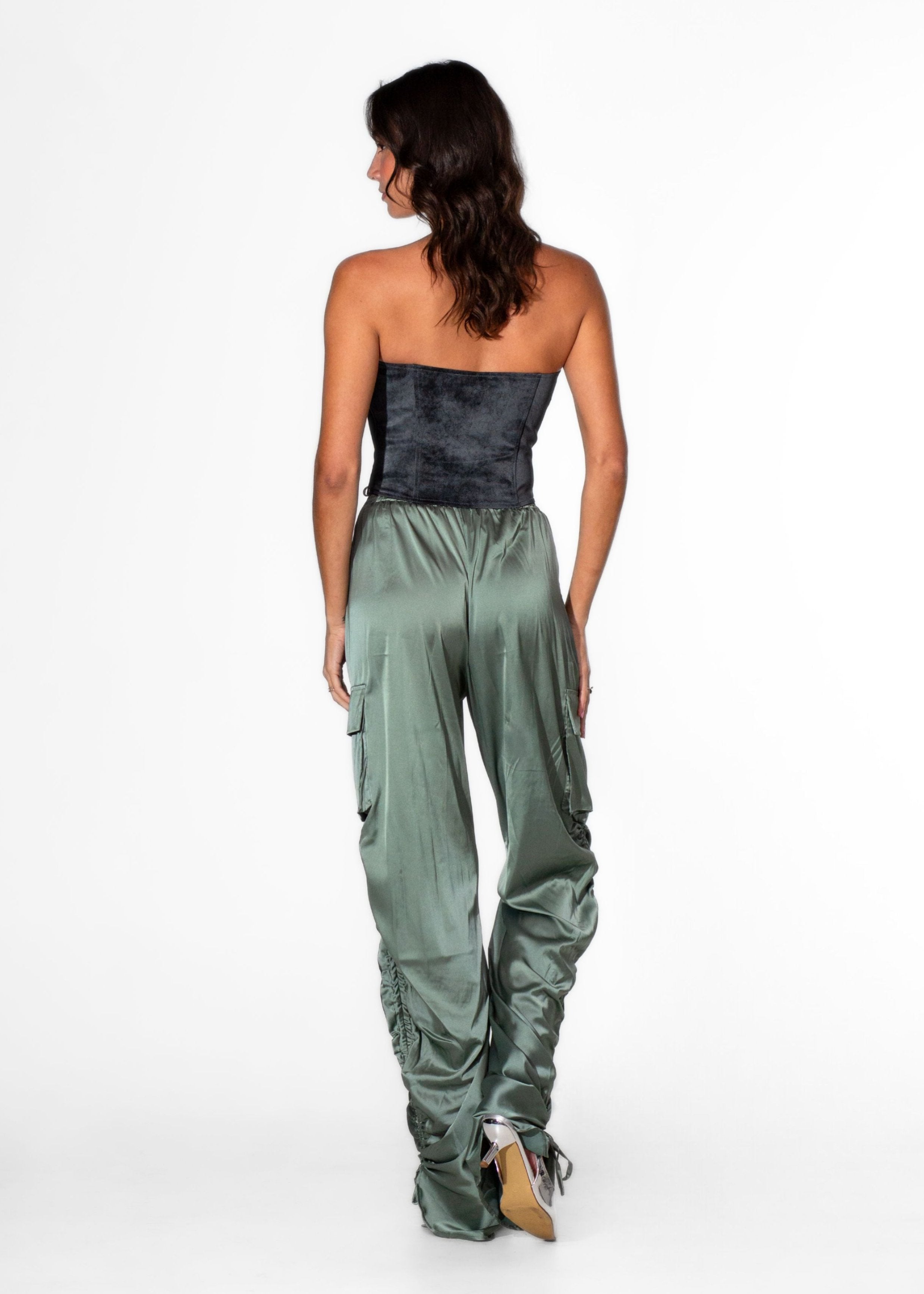 Back view of Laurenelle women’s black distressed pierced corset top highlighting its sleek faux suede design and pierced details.