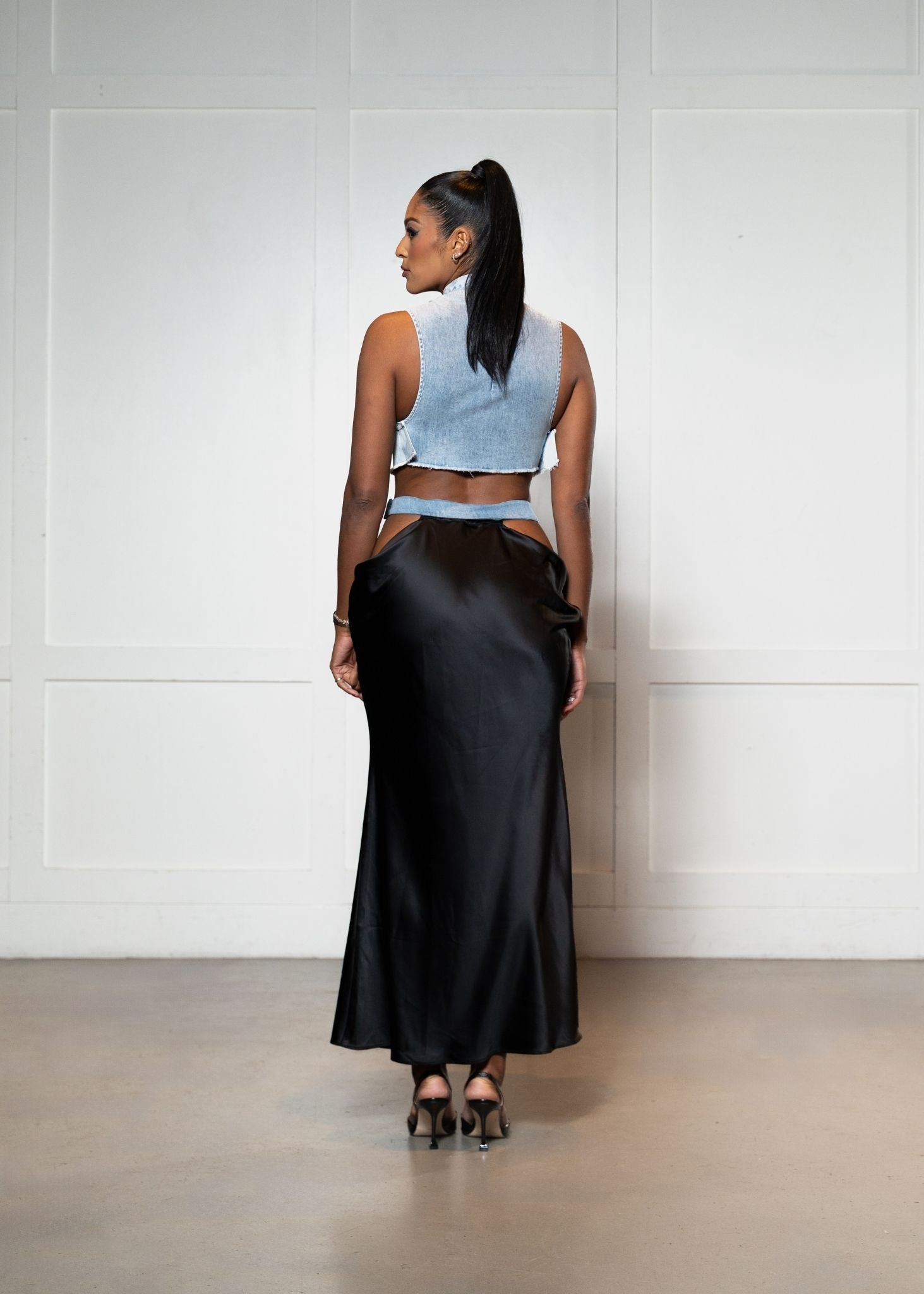 Laurenelle denim crop top and black satin cutout skirt back view. Stylish and contemporary fashion statement.