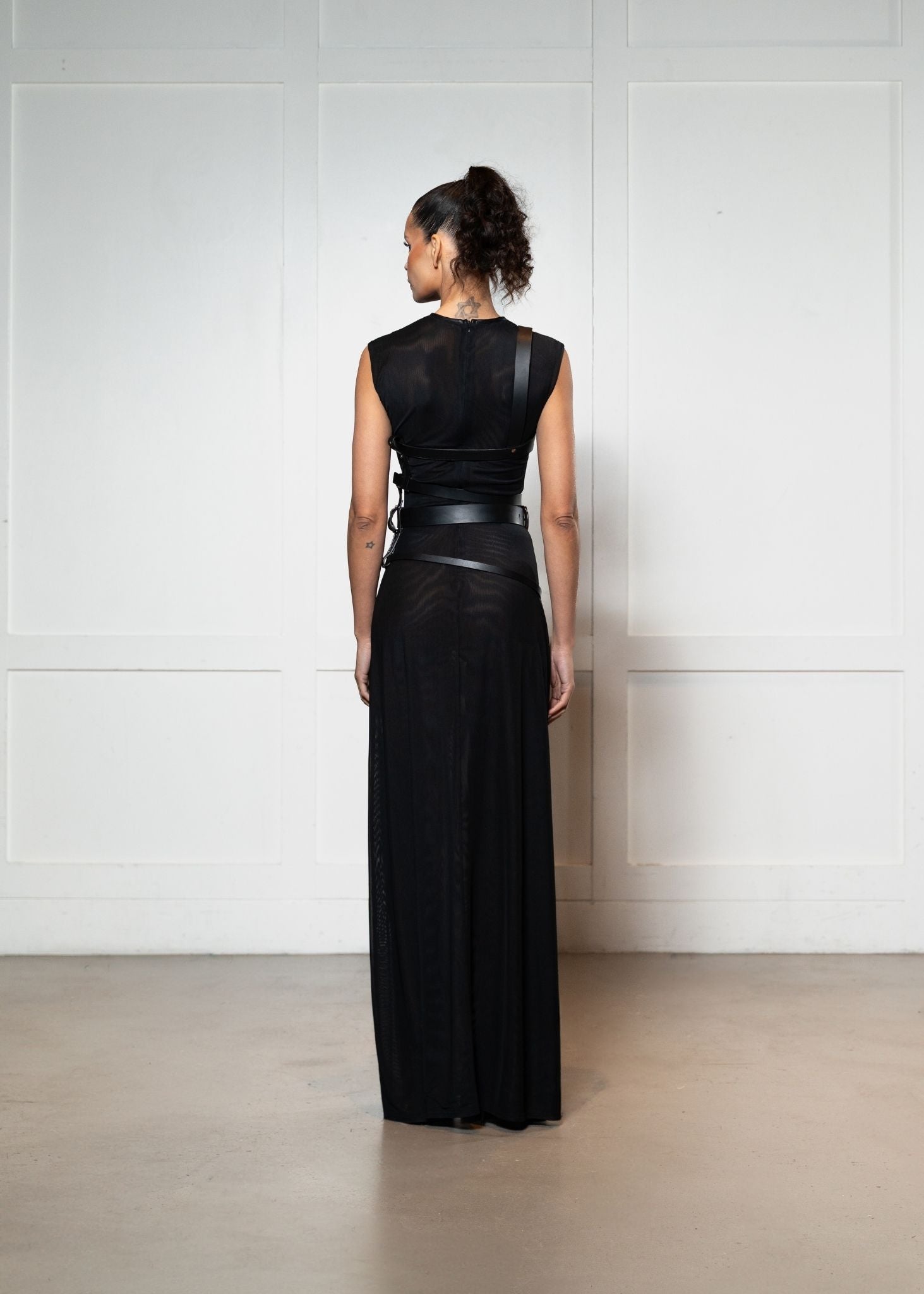 Laurenelle sheer dress with leather harness back view. Sleek and daring modern design.