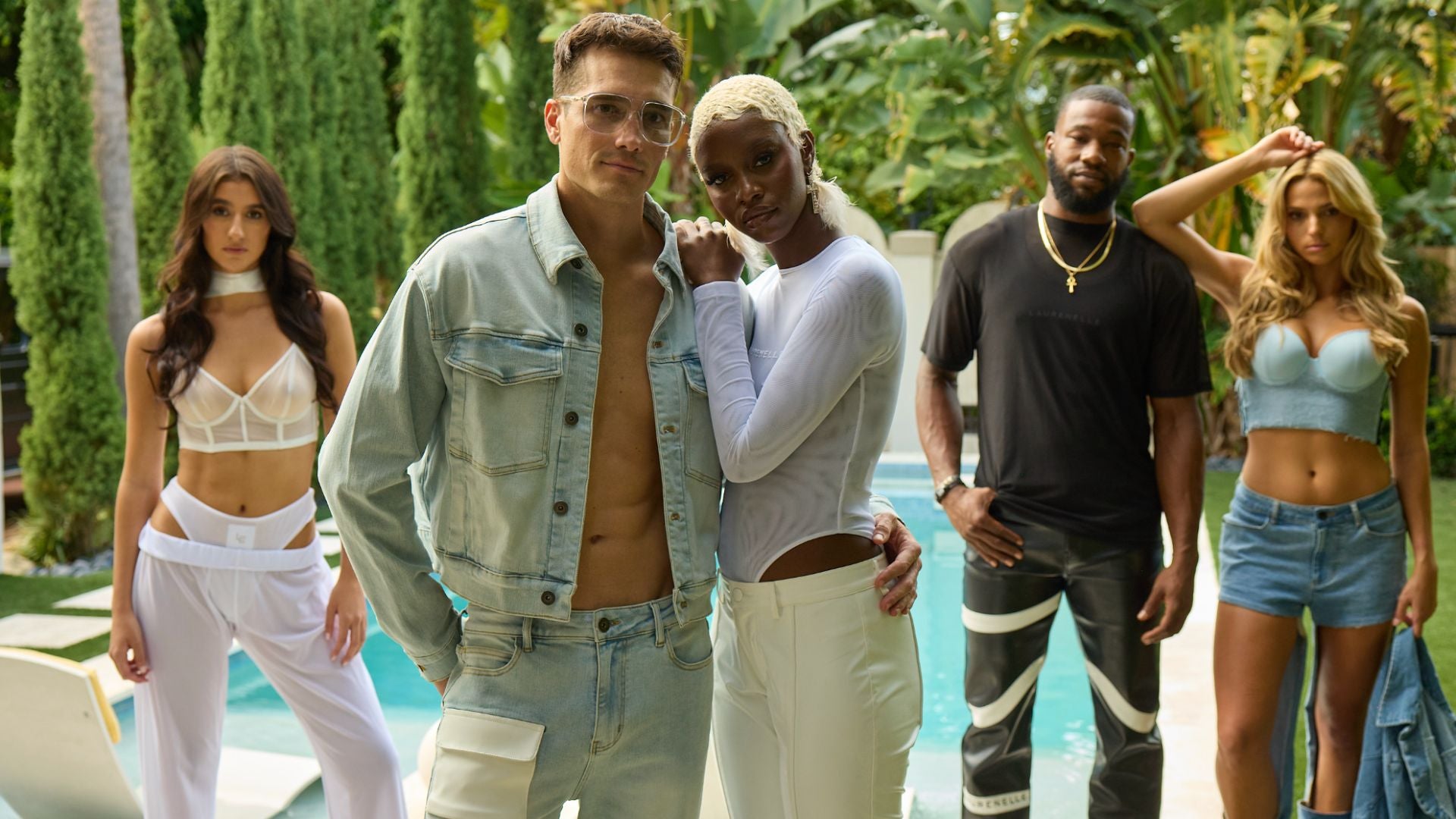 Laurenelle Spring Summer Collection featuring diverse models in luxury unisex fashion, styled in denim, sheer white sets, and statement streetwear, photographed poolside.