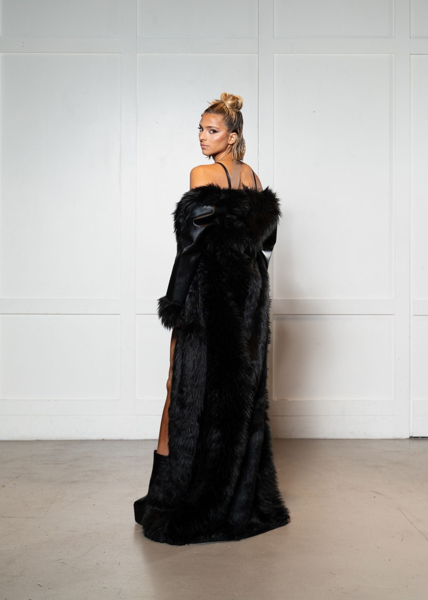 Laurenelle vegan leather long coat with faux fur back view. Elegant and warm winter fashion.