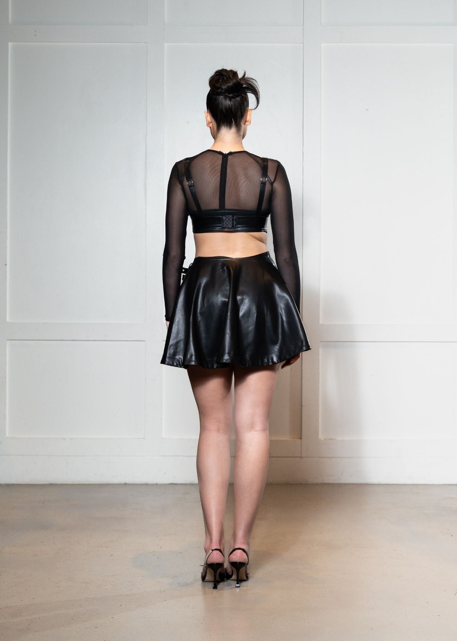 Laurenelle vegan leather skirt and crop top set back view. Sleek and stylish contemporary design.