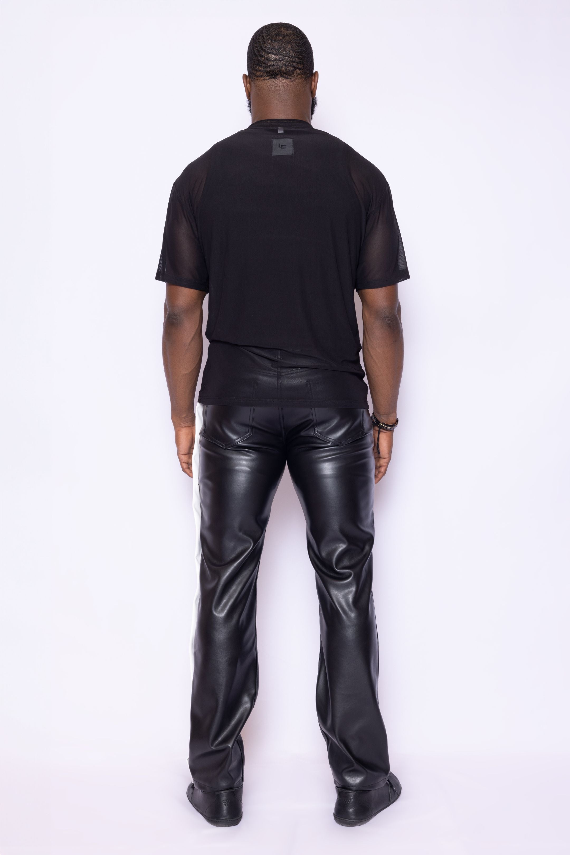 Back view of Laurenelle men’s black mesh shirt highlighting the rubber logo patch and breathable fabric.
