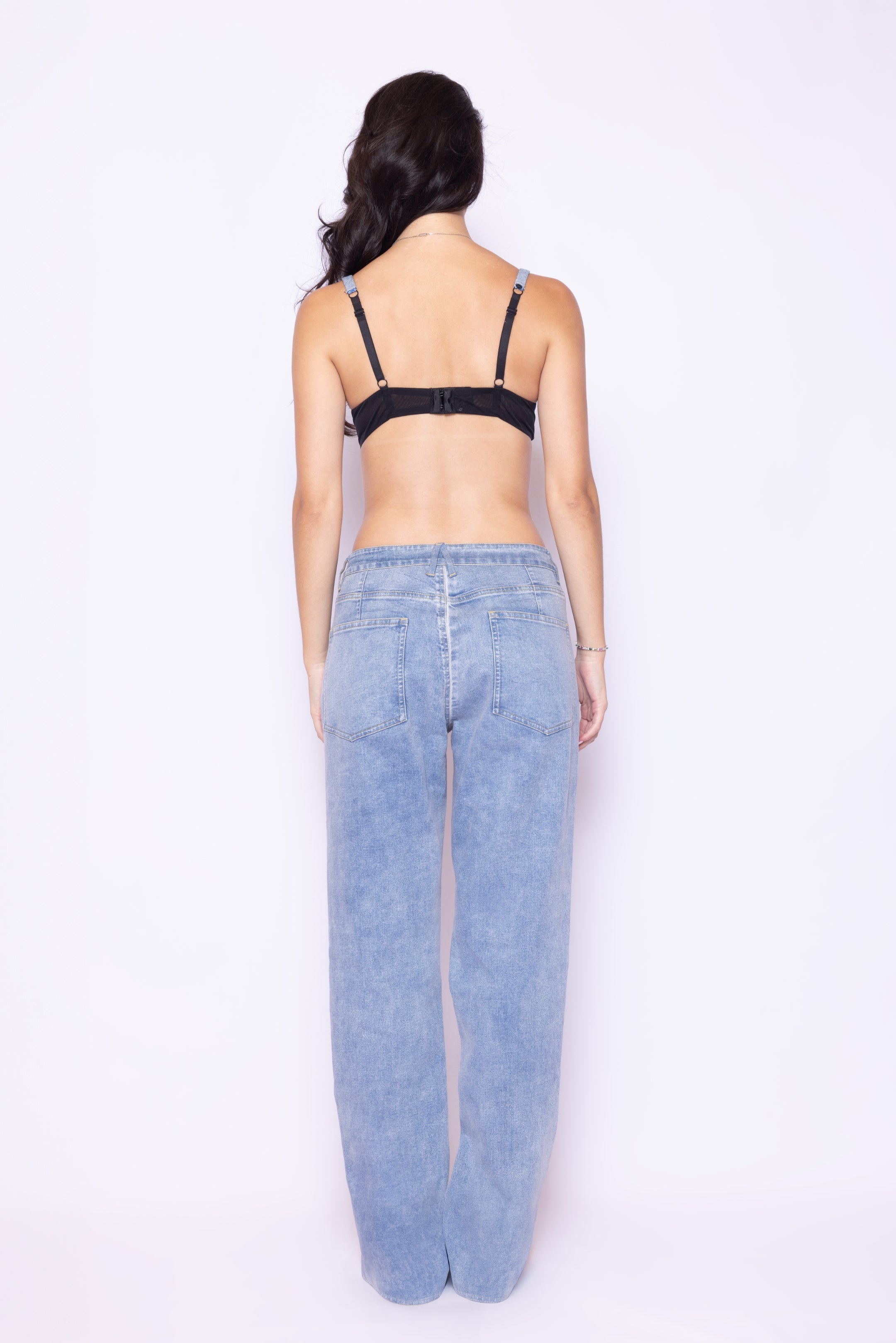 Back view of Laurenelle women’s mesh front denim back pants featuring lightwash denim and embroidered logo on the leg strip.