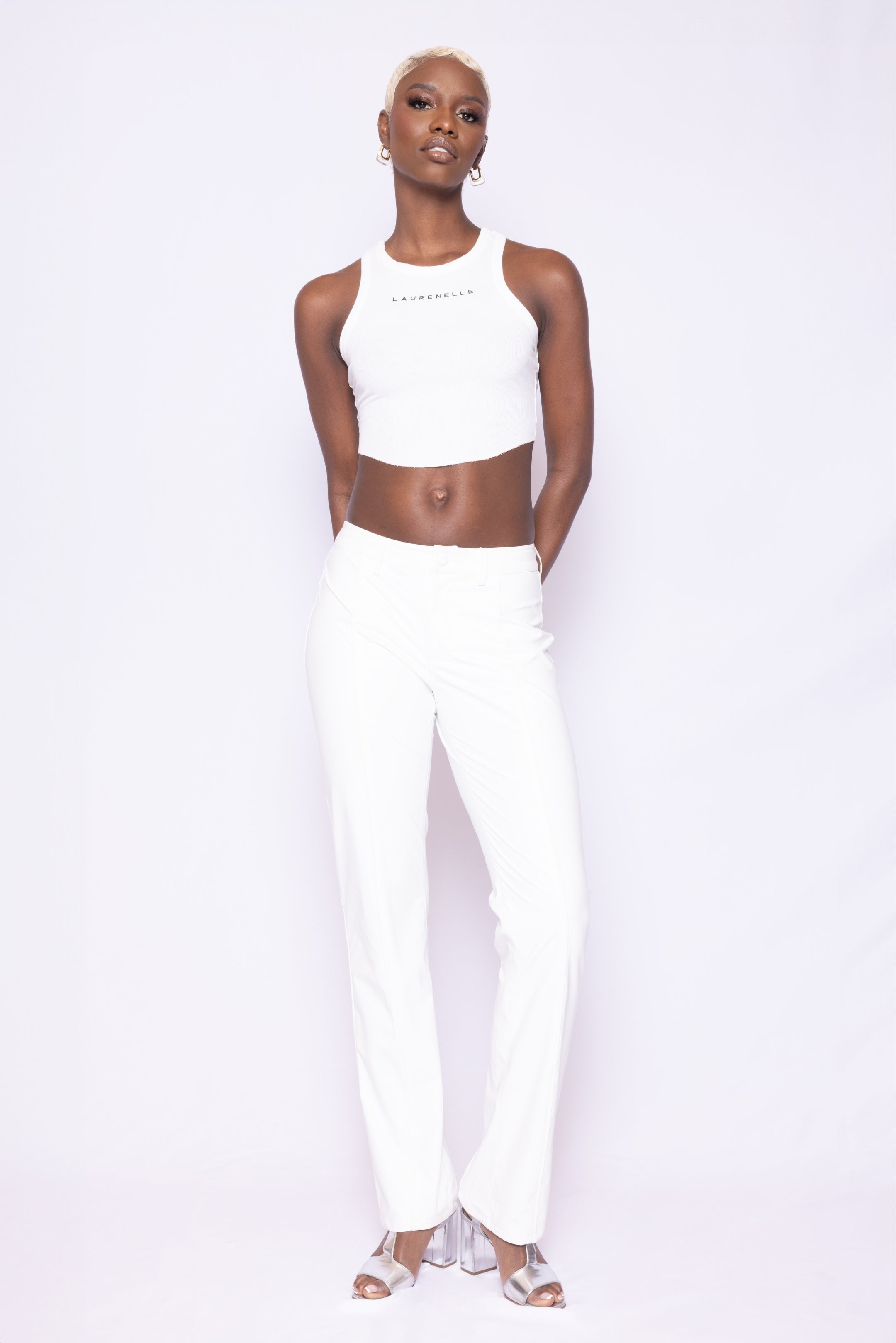 Third front view of Laurenelle women’s white vegan leather pants with soft stretch fabric and piping detail.